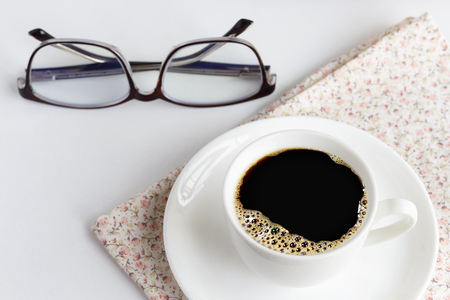 A cup of white coffee and glasses are placed on bright pink cloth.  The concept of relaxation with coffee in the morning.の写真素材