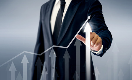 A successful businessman, hands touch the graph that represents profit rises on a lot more.の写真素材