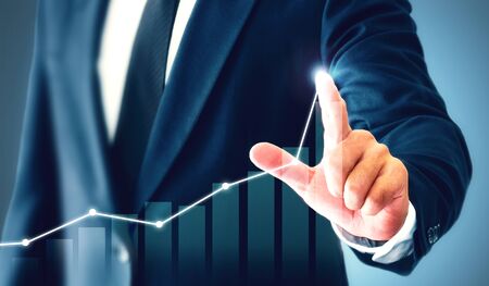 Businessman showing business growth on a chart, hands touch the graph that represents profit rises...