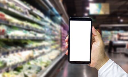 Shopper Mobile smart phone in hand, and see more detail and compare the prices in supermarkets.の写真素材
