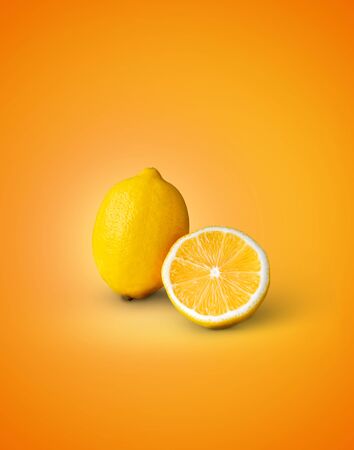 Fresh yellow lemon and slice of lemon on orange background.の写真素材