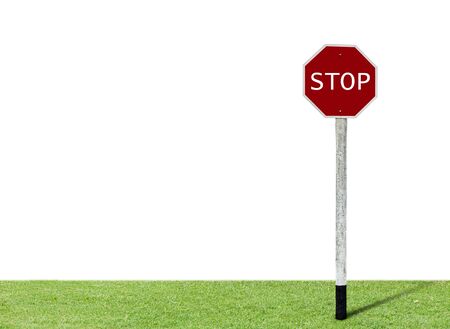 Stop sign on green grass with white background. の写真素材