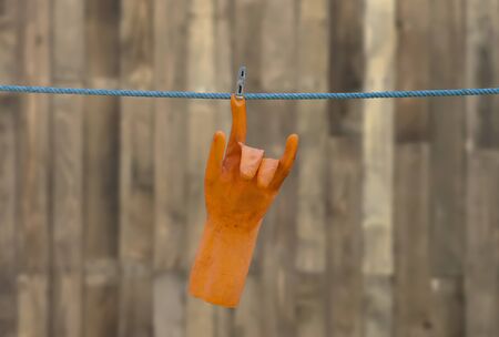 The orange rubber gloves are hanging on the plastic string.の写真素材