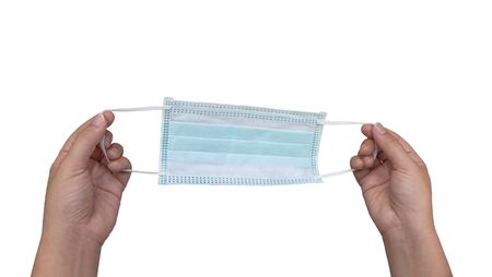 Woman's hand holding a medical mask on a separate white background. Doctor mask fitting over the nose and mouth to protect against dust or virus.の写真素材