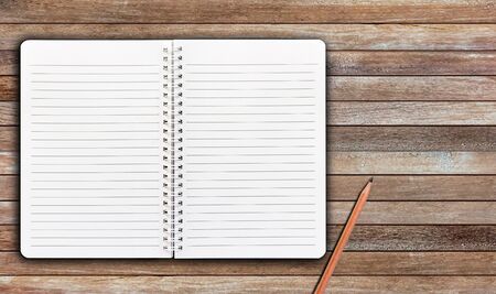 Notebook and pencil on wooden plank background with copy space for your text or image.の写真素材