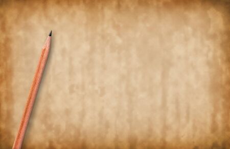 Brown pencils placed on old paper background with copy space for your image or text.の写真素材