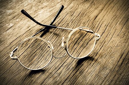 Vintage glasses isolated on the old wooden table with copy space for your text. の写真素材