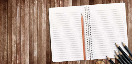 Notebook and pencil on wooden plank background with copy space for your text or image.の写真素材