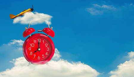 Alarm clock twin Bell-type red with airplane on blue sky background.の写真素材