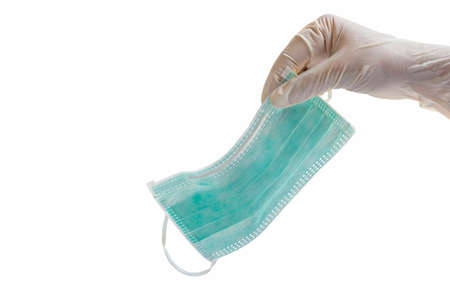 A man's hand holding a medical mask isolated on a white background