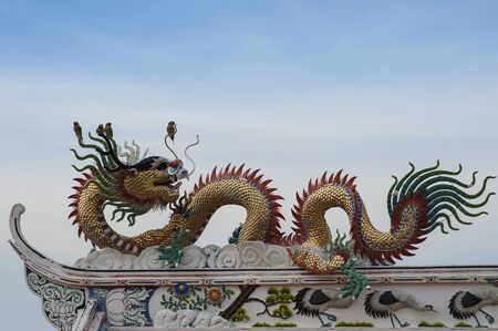 Golden dragon with clouds blue sky at chinese temple,Thailandの写真素材