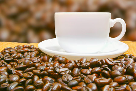 coffee in white cup on coffee bean table and blur backgroundの写真素材