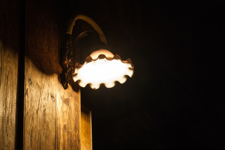 Thai old style Wall lamp on the old wooden wall