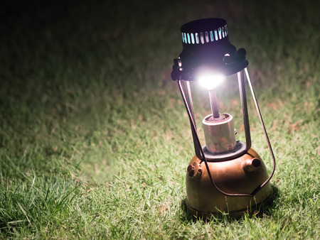 Ancient lamps illuminated with oil on the grass at night.の写真素材