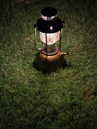Ancient lamps illuminated with oil on the grass at night.の写真素材