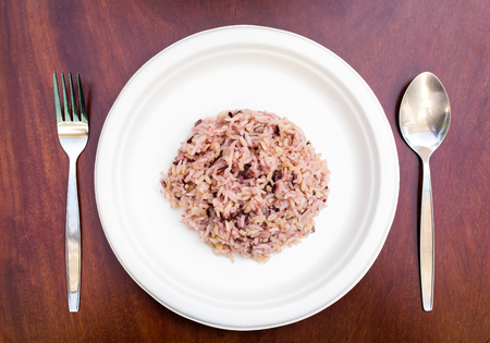 Gaba rice in a dish made of recycled materials on a wooden table with cutlery placed.の写真素材