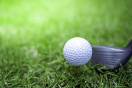 golf ball close-up in soft focus at sunlight with Green grass. wide landscape as background, Sport playground for golf club concept.shallow focus effect.の写真素材
