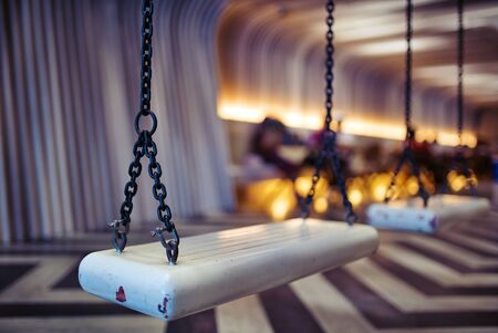 Black iron chain, hanging white swings Inside the empty room.shallow focus effect.