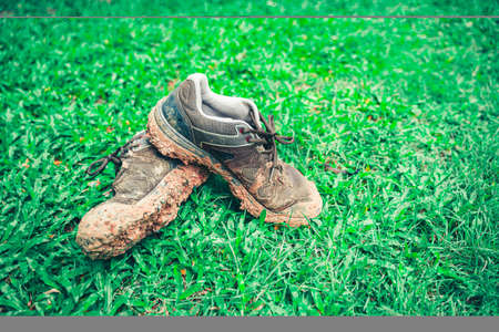 Hiking shoes There is a full mud floor. On the green grass.の写真素材