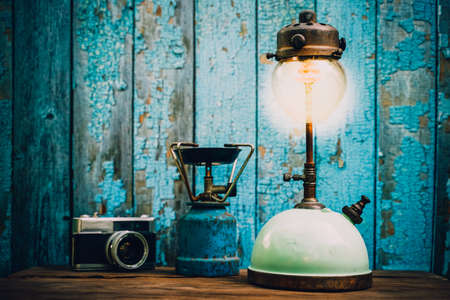 Antique kerosene lamps and old camera. on a wooden table on a green wooden background.vintage style.の写真素材