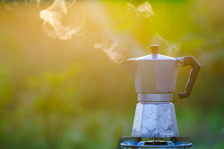 Moka pot and smoke, coffee bask on fire, In the forest at sunrise in the morning. soft focus.shallow focus effect.の写真素材