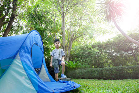 happy boy in camping tent.boy holding binoculars in adventure time.soft focus.の写真素材
