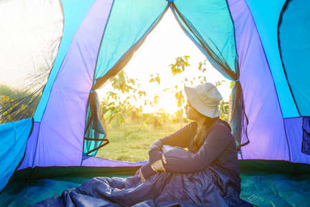 young girl relax inside the tent in the morning at sunrise in the forest. soft focus.の写真素材