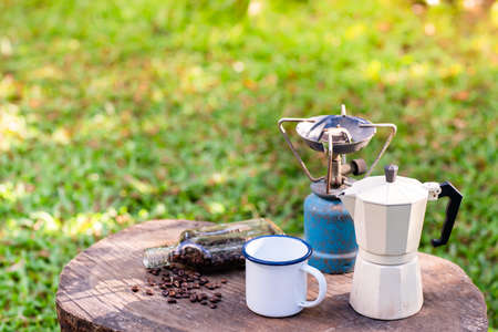 Selective focus white enamel coffee mug and morning coffee set in the garden.soft focus.shallow focus effect.の写真素材