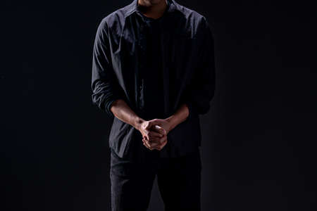 man in black in the studio emphasizes thoughtful thinking, thinking carefully, and trying to choose...