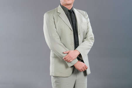 Businessman wearing an elegant suit over gray background. Well-dressed senior man in the studio That...