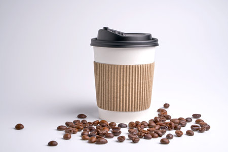 paper coffee cup on white background.foreground is coffee beans.の写真素材