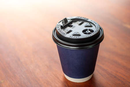blue Paper coffee cups on the wooden table in a coffee shop .soft focus.shallow focus effect.の写真素材