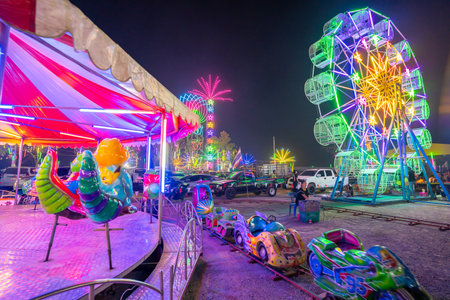 The amusement park in front of the Ferris wheel at night.の写真素材