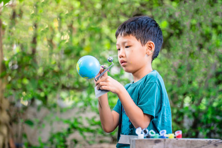 Concentrated asian boy coloring solar system toys, sensory activity, learning tools at home.の写真素材