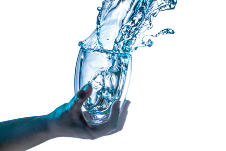 Drinking water splashing from the glass on white backgroundの写真素材
