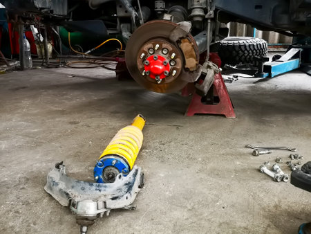 Car brake disc and shock absorber in auto repair shop garage.の写真素材