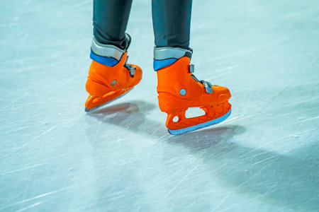 Close-up of a girl's legs in w fashion skates on an outdoor ice rink, a young girl skating thinking on the open rinkの写真素材