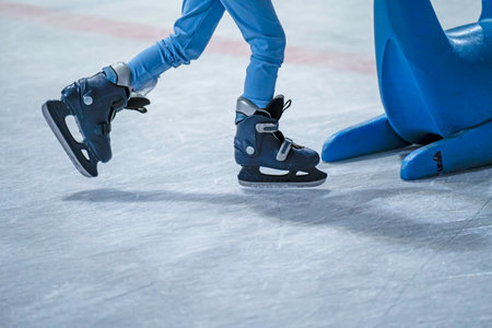 Close-up of a girl's legs in w fashion skates on an outdoor ice rink, a young girl skating thinking on the open rinkの写真素材