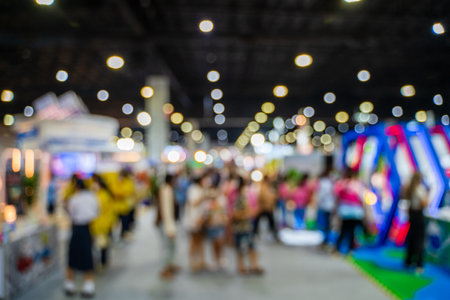 Blurred images of trade fairs in the big hall. image of people walking on a trade fair exhibition or expo where business people show innovation activity and present products in a big hall.の写真素材