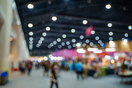 Blurred images of trade fairs in the big hall. image of people walking on a trade fair exhibition or expo where business people show innovation activity and present products in a big hall.の写真素材