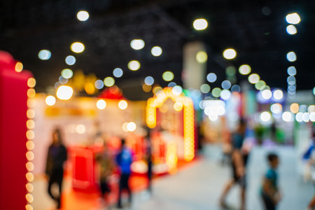 Blurred images of trade fairs in the big hall. image of people walking on a trade fair exhibition or expo where business people show innovation activity and present products in a big hall.の写真素材