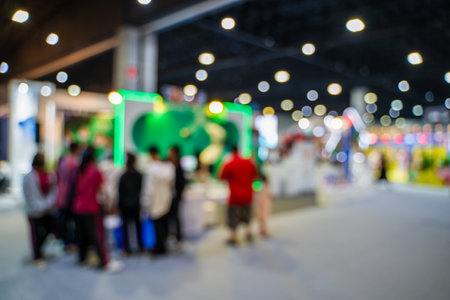 Blurred images of trade fairs in the big hall. image of people walking on a trade fair exhibition or expo where business people show innovation activity and present products in a big hall.の写真素材