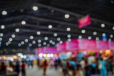 Blurred images of trade fairs in the big hall. image of people walking on a trade fair exhibition or expo where business people show innovation activity and present products in a big hall.の写真素材