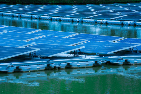 Side view of solar panels floating on water in a lake, for generating electricity from sunlight, selective focus, soft focus.の写真素材