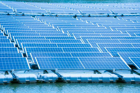 Side view of solar panels floating on water in a lake, for generating electricity from sunlight, selective focus, soft focus.の写真素材