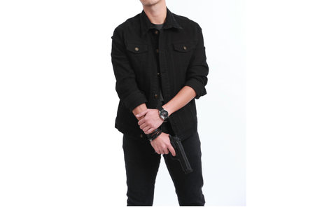 man holding a gun like a secret agent on a white backgroundの写真素材