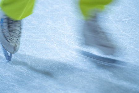 Blurred movement of skates on an outdoor ice rink. Young girl skating thinking on the open rink