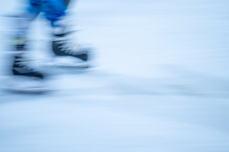 Blurred movement of skates on an outdoor ice rink. Young girl skating thinking on the open rinkの写真素材