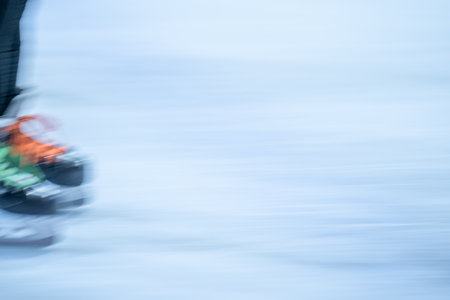 Blurred movement of skates on an outdoor ice rink. Young girl skating thinking on the open rink