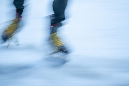 Blurred movement of skates on an outdoor ice rink. Young girl skating thinking on the open rinkの写真素材